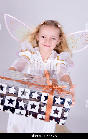 Ragazza come angelo con regalo di Natale Foto Stock