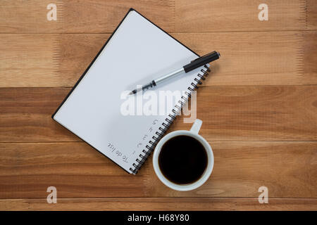 Close-up della tazza di caffè con un diario e penna Foto Stock