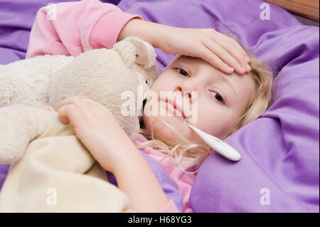Malata con termometro clinico a letto Foto Stock