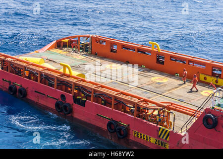 Equipaggio di offshore a camminare su una piattaforma vuota del rimorchiatore a traino Foto Stock