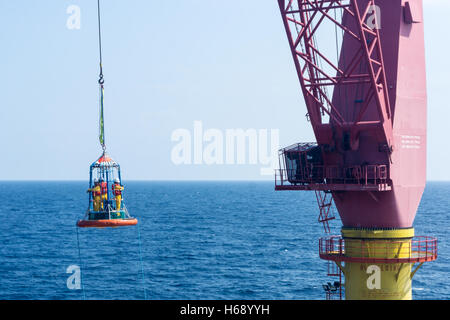 Offshore di lavoratore di essere trasferito alla barca personale utilizzando il trasferimento di cestello Foto Stock