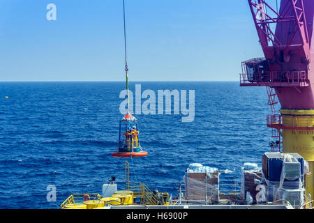 Offshore di lavoratore di essere trasferito alla barca personale utilizzando il trasferimento di cestello Foto Stock