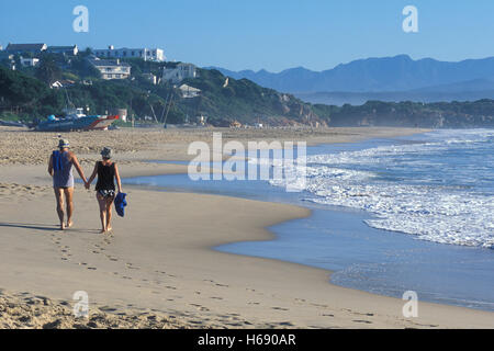 Coppia di anziani di camminare sulla spiaggia nella Baia Plettenberg, Garden Route, Western Cape, Sud Africa e Africa Foto Stock