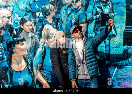 New York, NY - 23 ottobre 2016 Giovane prendendo un selfie davanti a Logan Hicks murale " la storia della mia vita." Bowery murale ©Stacy Rosenstock Walsh Foto Stock