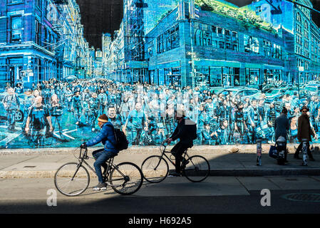 New York, NY - i ciclisti e i pedoni n'East Village, passare un murale di Logan Hick, intitolato La storia della mia vita, che dispone di una folla di persone che ha fotografato su un angolo della molla e Greene Street. ©Stacy Rosenstock Walsh Foto Stock