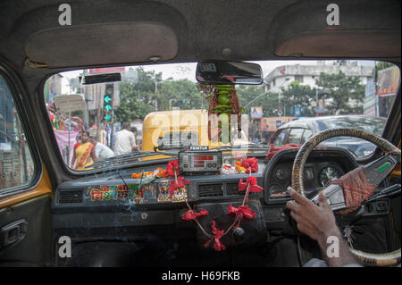 Dio foto e tigli e chilis (Hindu buona fortuna charms) appendere insid taxi in Kolkata West Bengal India. Foto Stock