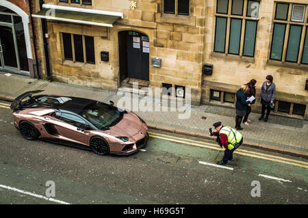 Traffico funzionario Enforcment registrazione parcheggiati illegalmente Lamborghini in Leicester Foto Stock