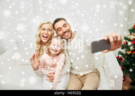 Famiglia tenendo selfie con lo smartphone a natale Foto Stock