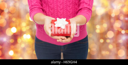 Close up della donna in maglia rosa azienda confezione regalo Foto Stock