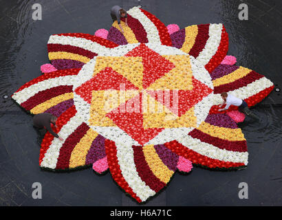 Solo uso editoriale artisti floreali (sinistra-destra) Richard Bragg, Harriet Sargent e James Buswell ha messo i tocchi di rifinitura per un 9x9m rangoli-stile di installazione di fiori nella fontana a Cabot Square, Canary Wharf, London, realizzata con oltre 6 mila fiori per celebrare Diwali, la festa della luce. Foto Stock