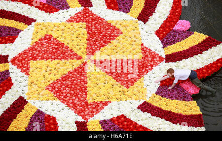 Solo uso editoriale Floral artista James Buswell mette la rifinitura di un 9x9m rangoli-stile di installazione di fiori nella fontana a Cabot Square, Canary Wharf, London, realizzata con oltre 6 mila fiori per celebrare Diwali, la festa della luce. Foto Stock