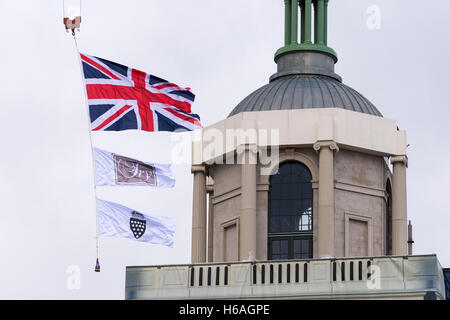 Poundbury, Dorset, Regno Unito. 26 ott 2016. Regno Unito Meteo. La regina madre piazza di Poundbury nel Dorset essendo predisposta per la visita della Regina di domani (Giovedi 27th) per lo scoprimento della statua della regina madre. Anche in partecipazione per l'inaugurazione sarà il Duca di Edimburgo, il principe Carlo e Camilla. La bandiera europea, Fry bandiera e Ducato di Cornovaglia battenti bandiera da una gru accanto alla torre sul Royal Pavilion. Credito Foto: Graham Hunt/Alamy Live News Foto Stock