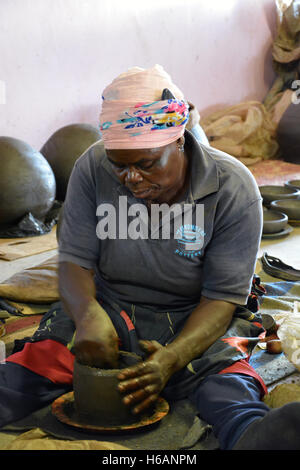 Una donna dimostra come ella crea le pentole di creta in vendita presso la Ceramica Mukondeni nella regione di Limpopo del Sud Africa. Foto Stock