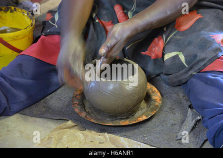 Una donna dimostra come ella crea le pentole di creta in vendita presso la Ceramica Mukondeni nella regione di Limpopo del Sud Africa. Foto Stock