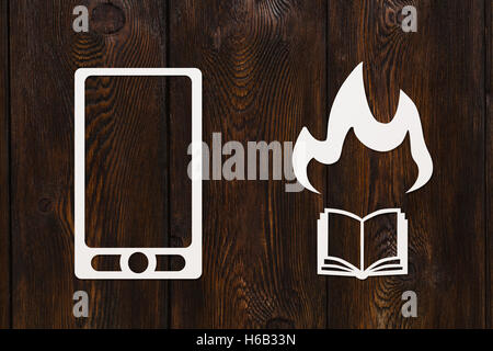 Lo smartphone di carta e la masterizzazione prenota vicino a. Moderno concetto di lettura. Abstract immagine concettuale. Copyspace. Scuro dello sfondo in legno Foto Stock