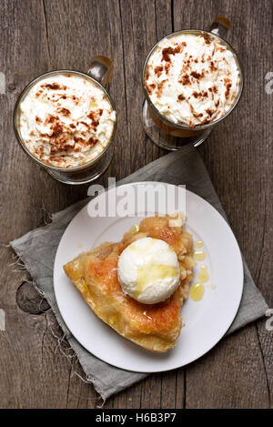 Pezzo di torta di mele servita con gelato di zucca e latte in bicchieri, vista dall'alto Foto Stock