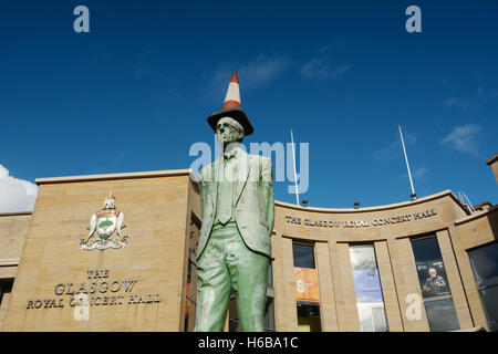 Regno Unito, Scozia, Glasgow, statua di Donald Dewar di fronte alla Glasgow Royal Concert Hall, rosso con cono di traffico sulla testa Foto Stock