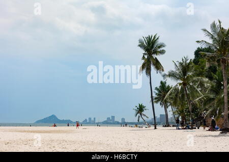 Hua Hin, Tailandia - 23 Ottobre 2016: vista alla spiaggia della città di giorno con pochi turisti a prendere il sole e gli alberi di cocco Foto Stock