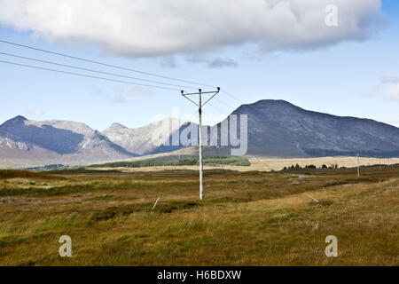 Scenic paesaggio montuoso in Connemara Irlanda con linee elettriche in primo piano Foto Stock