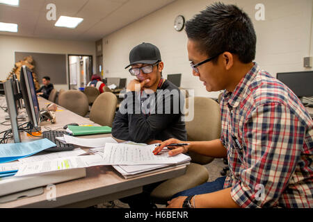 Un americano asiatico tutor assiste uno studente ispanica nel learning center di Santa Ana CA Community College. Foto Stock