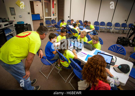 Un insegnante di scuola elementare aiuta i suoi studenti con una classe di animazione digitale il progetto in Mission Viejo, CA. Nota colorato progetto T Shirts. Foto Stock