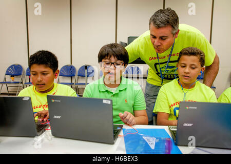 Un insegnante di scuola elementare aiuta i suoi studenti con una classe di animazione digitale il progetto in Mission Viejo, CA. Nota colorato progetto T Shirts. Foto Stock