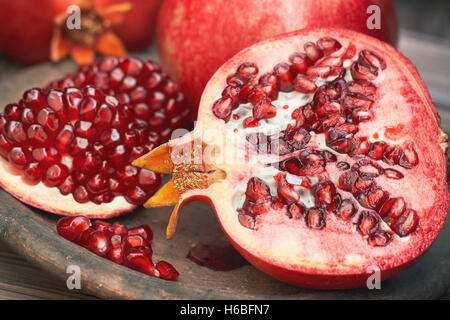 Mature melograno frutto servito sulla piastra rustico Foto Stock