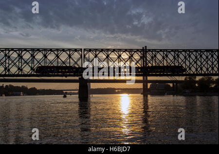 Belgrado, Serbia - Treno attraversando il ponte sul fiume Sava al crepuscolo Foto Stock