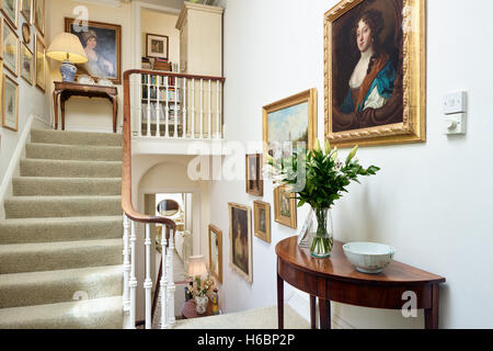 Nella tromba delle scale in un periodo georgiano appartamento mostra mobili di antiquariato e dipinti. Gloucestershire, Regno Unito Foto Stock