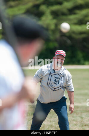 Una brocca si affaccia una pastella in un vintage Baseball gioco in una giornata di sole. Foto Stock