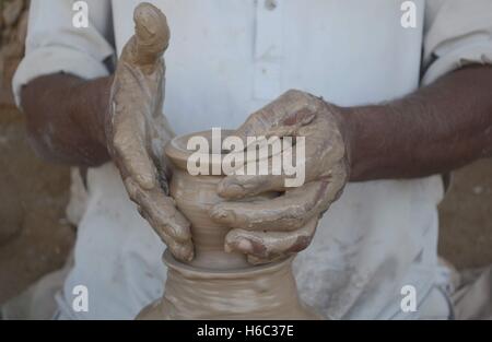 Hyderabad, Pakistan. 26 ott 2016. Un vasaio è occupato nella produzione di fango articoli di argilla e fango lampade ad olio a vi in ceramica come le esigenze di queste lampade a olio aumenta in Diwali la grande festa in indù. Il potter ha detto che in Diwali hanno reso 2000 lampade a olio ogni giorno. © Janali Laghari/Pacific Press/Alamy Live News Foto Stock