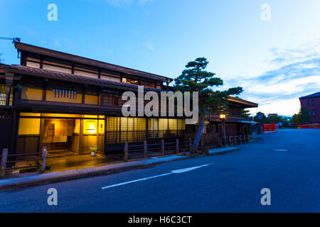 Naka-bashi bridge nella parte anteriore del tradizionale giapponese case di legno illuminata anche di sera al tramonto nella storica città vecchia Takayama Foto Stock