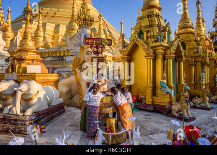 Persone che fanno i rituali religiosi presso la pagoda di Shwedagon tempio di Yangon Foto Stock