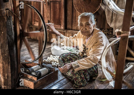 Lavoratore di sesso femminile tesse tessuto in una fabbrica di tessitura sul Lago Inle. Foto Stock