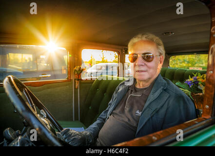 Senior uomo nel sedile del conducente di un vecchio classico Buick modello 60 dal 1932, Reykjavik, Islanda Foto Stock