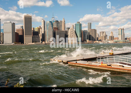 Il vento, increspato acque dell'East River rottura nei confronti di un frangiflutti in Ponte di Brooklyn Park di New York di domenica 23 ottobre, 2016. Le raffiche di vento hanno raggiunto 55 mph con la città di emettere un avviso di vento. Il lunedì è previsto per essere più caldo con meno vento. (© Richard B. Levine) Foto Stock