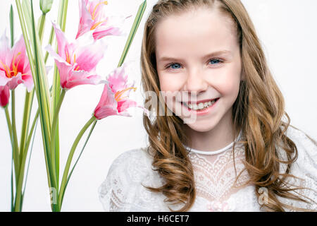 Close up studio bellezza ritratto della comunione carina ragazza con fiori. Foto Stock