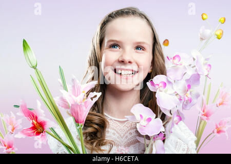 Close up divertente ritratto di comunione ragazza con fiori colorati. Foto Stock