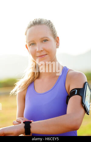 Close up ritratto di attraente giovane donna indossa smart watch e smart watch bracciale. Giovane atleta nello sport usura. Foto Stock