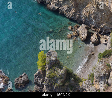Vista dall'alto di una spiaggia con sabbia dorata, rocce e mare azzurro Foto Stock