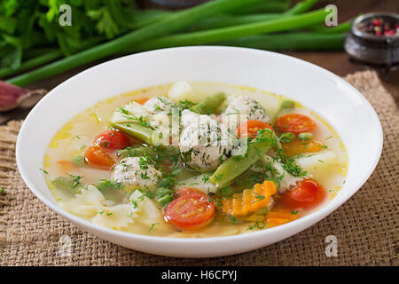 La dieta zuppa di verdure con polpette di pollo e erbe aromatiche fresche nel recipiente Foto Stock