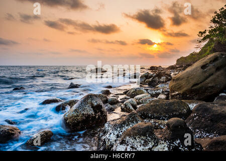 Tramonto a costa rocciosa vicino a Long Beach in Sok villaggio San su Koh Rong isola, Krong Preah Sihanouk, Sihanoukville, Cambogia Foto Stock