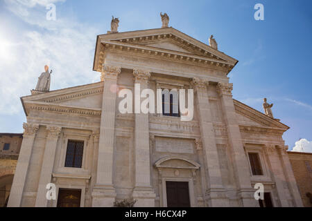Facciata del Duomo di Santa Maria Assunta a Urbino, Marche, Italia. Sul tetto tre statue sulle virtù teologali: fede, speranza, Foto Stock