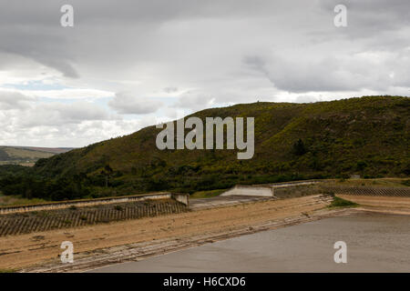 Vista ravvicinata del livello basso di acqua presso la diga Loerie in un giorno nuvoloso. Foto Stock