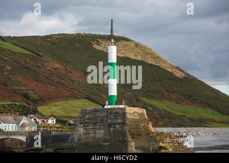 Aberystwyth pausa mare faro sull'entrata del porto con la penna dinas in background Foto Stock