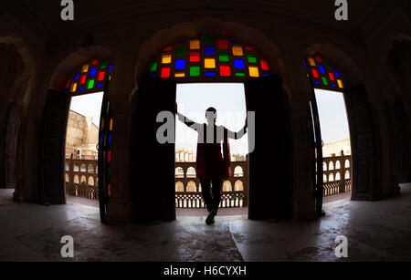 Donna con sciarpa in silhouette in piedi in arco con mosaico di vetro di Hawa Mahal, Rajasthan, India Foto Stock