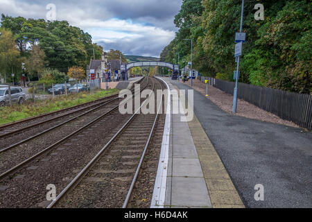 Le linee ferroviarie e la piattaforma a Pitlochry stazione con una passerella in distanza. Foto Stock