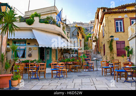 L'antico caffè Greco circondato da piccoli tavoli nel cortile con vista sull'Acropoli sulla cima della collina. Foto Stock