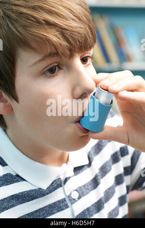 Boy utilizzando Inalatore per trattare asma attacco Foto Stock