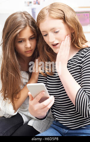 Ragazza con un amico di essere vittima di bullismo mediante messaggio di testo Foto Stock